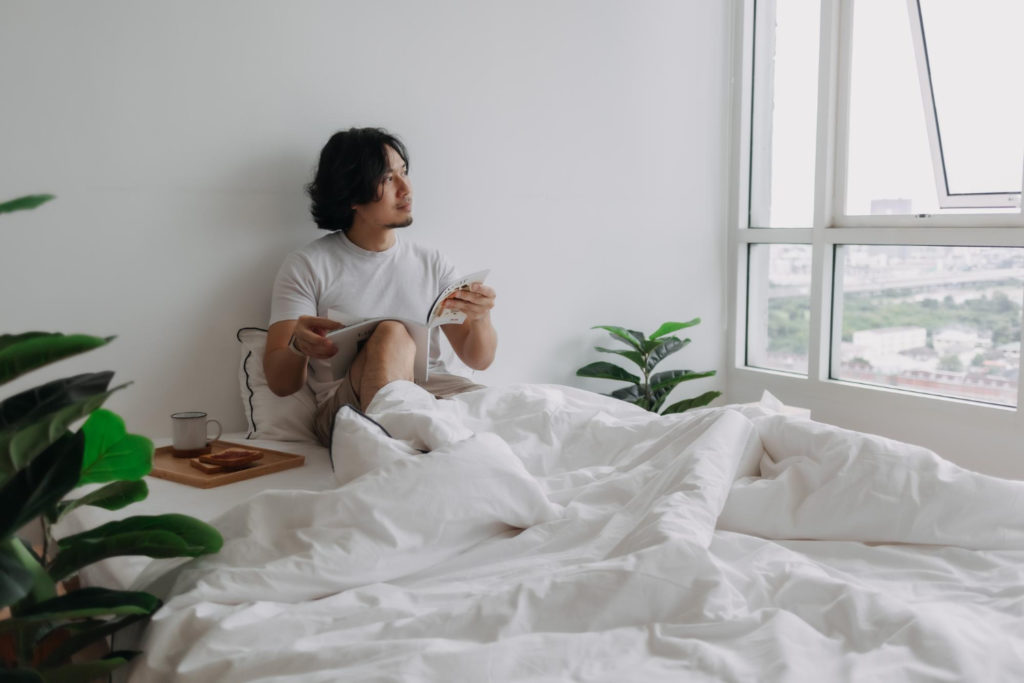A man reading a magazine on the bed